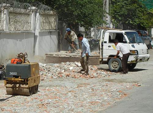 Using rubble to pave a muddy area.