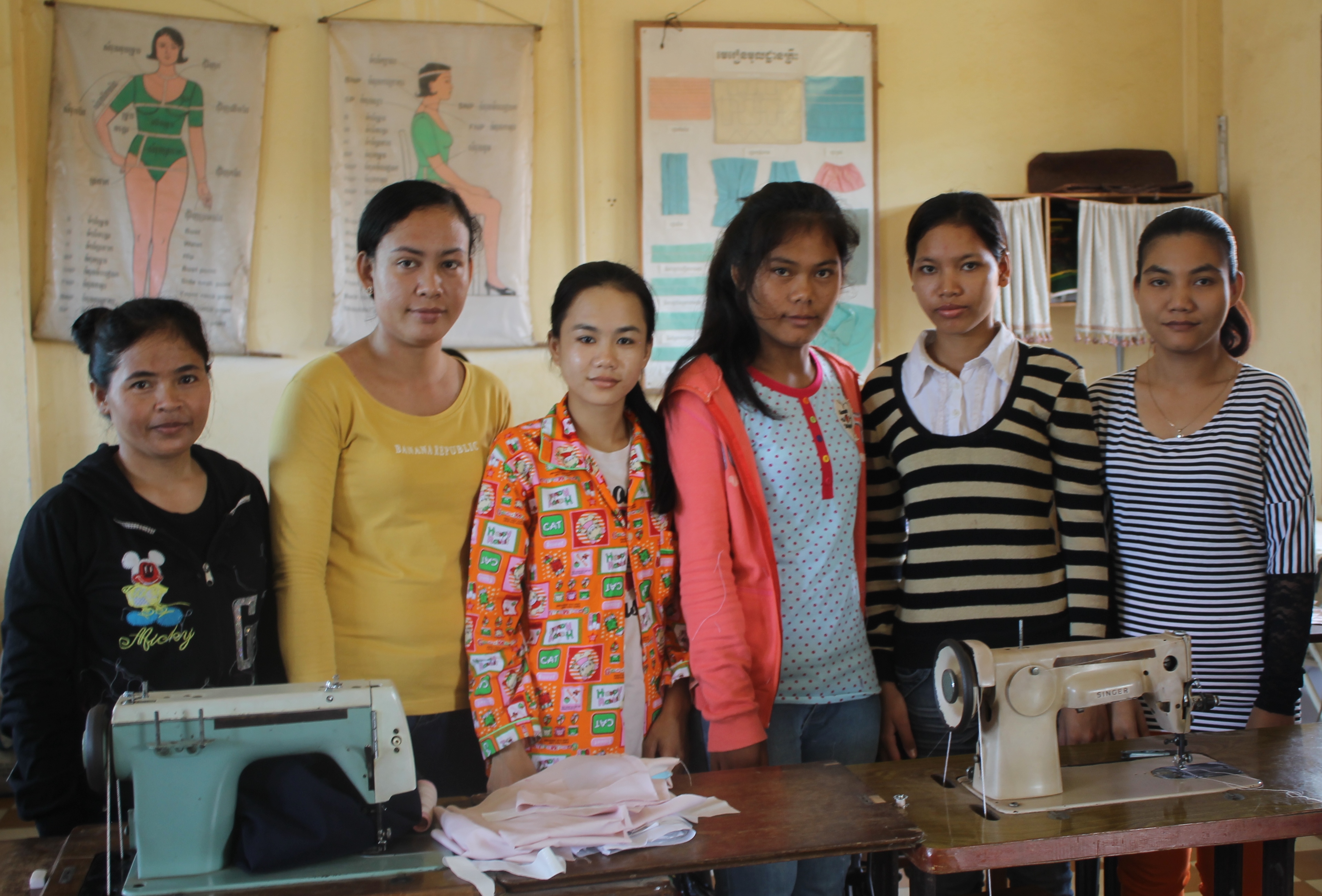 From left to right, our four new tailoring students with two previous students that now work at the training center.