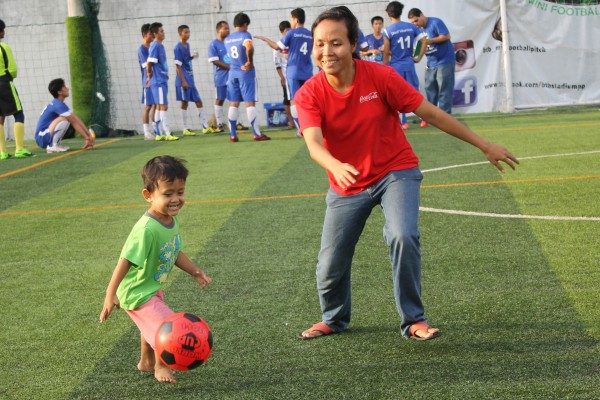 Mom and son playing at halftime, he wants to be just like his father.