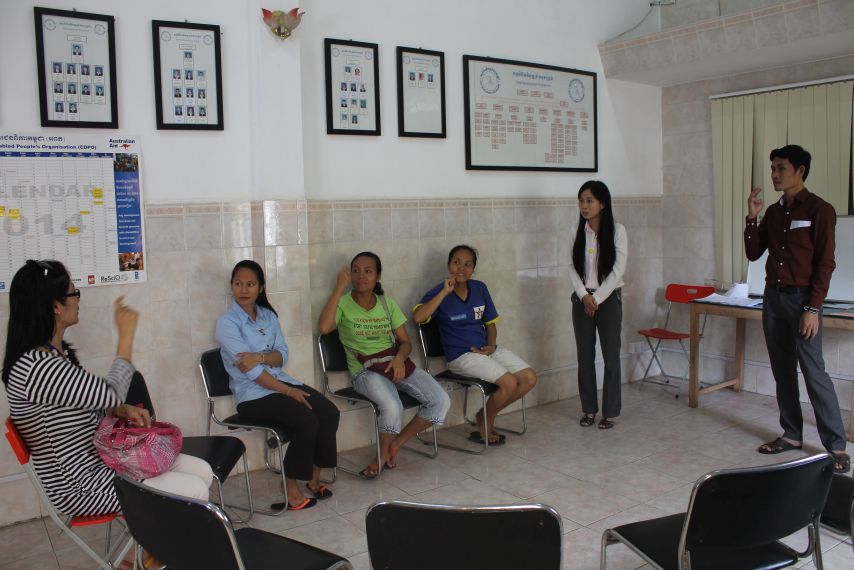 CSL Teachers, and Deaf community members, teach one of our visitors some signs