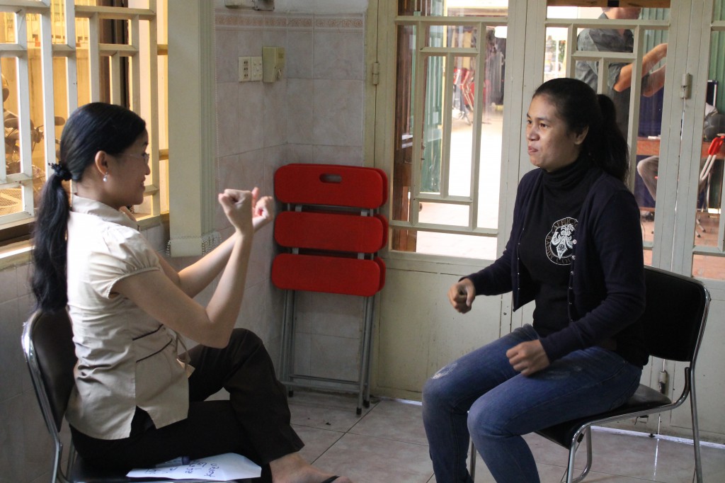 Interpreter trainee, Luckyna, practices her sign language with CSL teacher Kimhorn