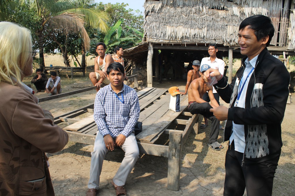 DDP Field Workers discussing one very shy, deaf youth and how to best encourage him to study.  Nearly 20 hearing villagers followed our team to see what brought us to the village.