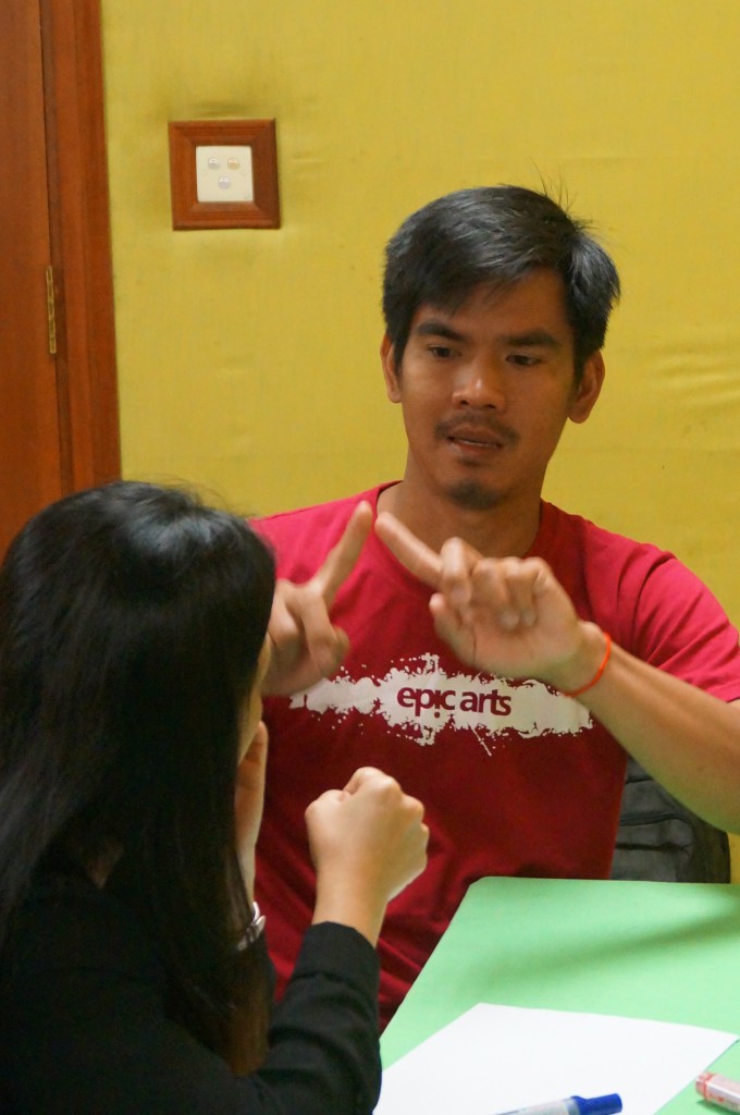 A deaf participant from Epic Arts explains to another deaf participant from Phnom Penh the problems he sees in Kampot.